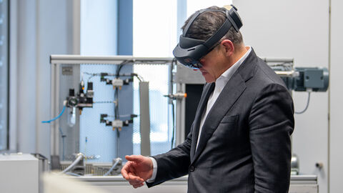 Ministerpräsident Rhein mit einer Augmented Reality-Brille auf dem Kopf