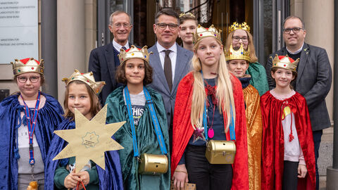 Staatsminister Wintermeyer und Ministerpräsident Rhein mit einer Gruppe Sternsinger vor der Staatskanzlei