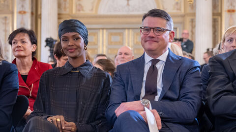 llwad Elman sitzt neben Ministerpräsident Rhein bei der Verleihung des Hessischen Friedenspreises 2022