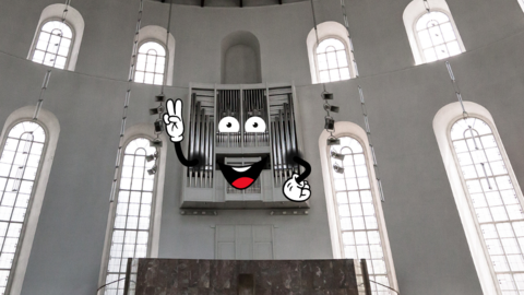 Die Orgel an der Wand der Paulskirche mit digitalen Cartoon Elementen verziert, sodass sie ein lachendes Gesicht und Hände hat. Sie macht ein Peacezeichen.