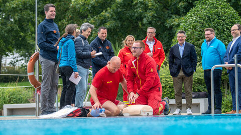 Ministerpräsident Boris Rhein mit Ehrenamtlichen der DLRG im Freibad Friedrichsdorf