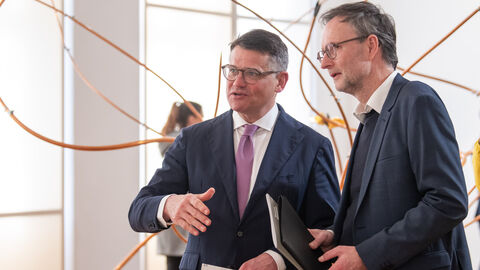 Ministerpräsident Rhein (links) steht neben Dr. Andreas Henning, dem Direktor des Museums Wiesbaden. Hinter ihnen eine der Kunstinstallationen der Künstlering Rebecca Horn.