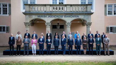 26 Personen stehen in zwei Reihen vor einem alten Gebäude mit der Aufschrift "Museum Jagdschloss Kranichstein"