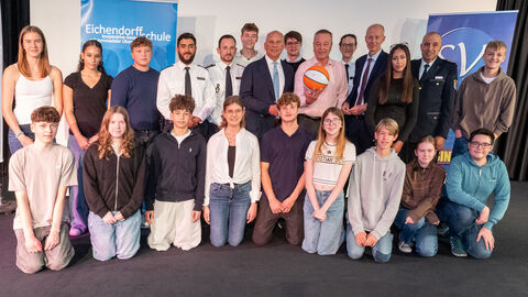 Mehrere Personen (darunter Polizeibeamte sowie Schüler) stehen nebeneinander.